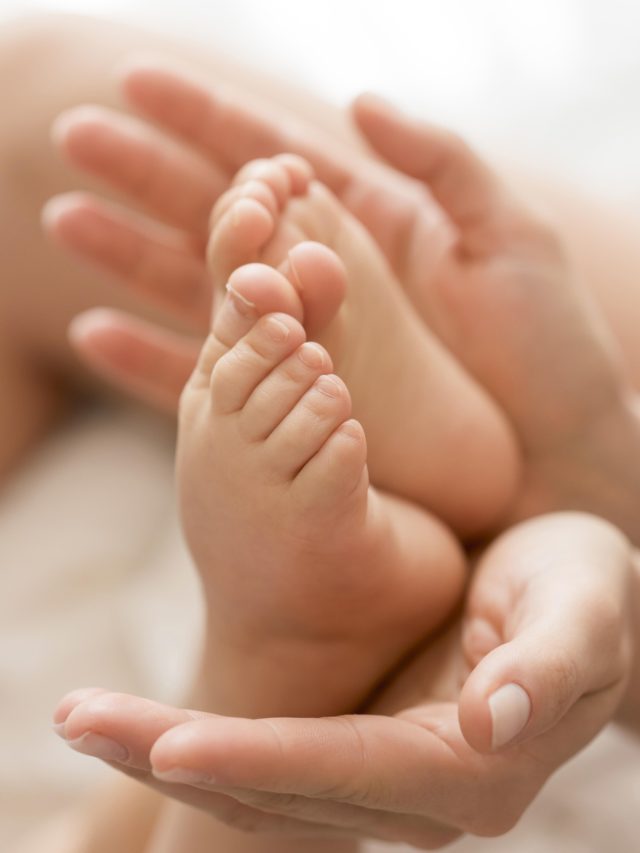 mae_de_close_up_segurando_os_pes_do_bebe_nas_maos-119494_1080